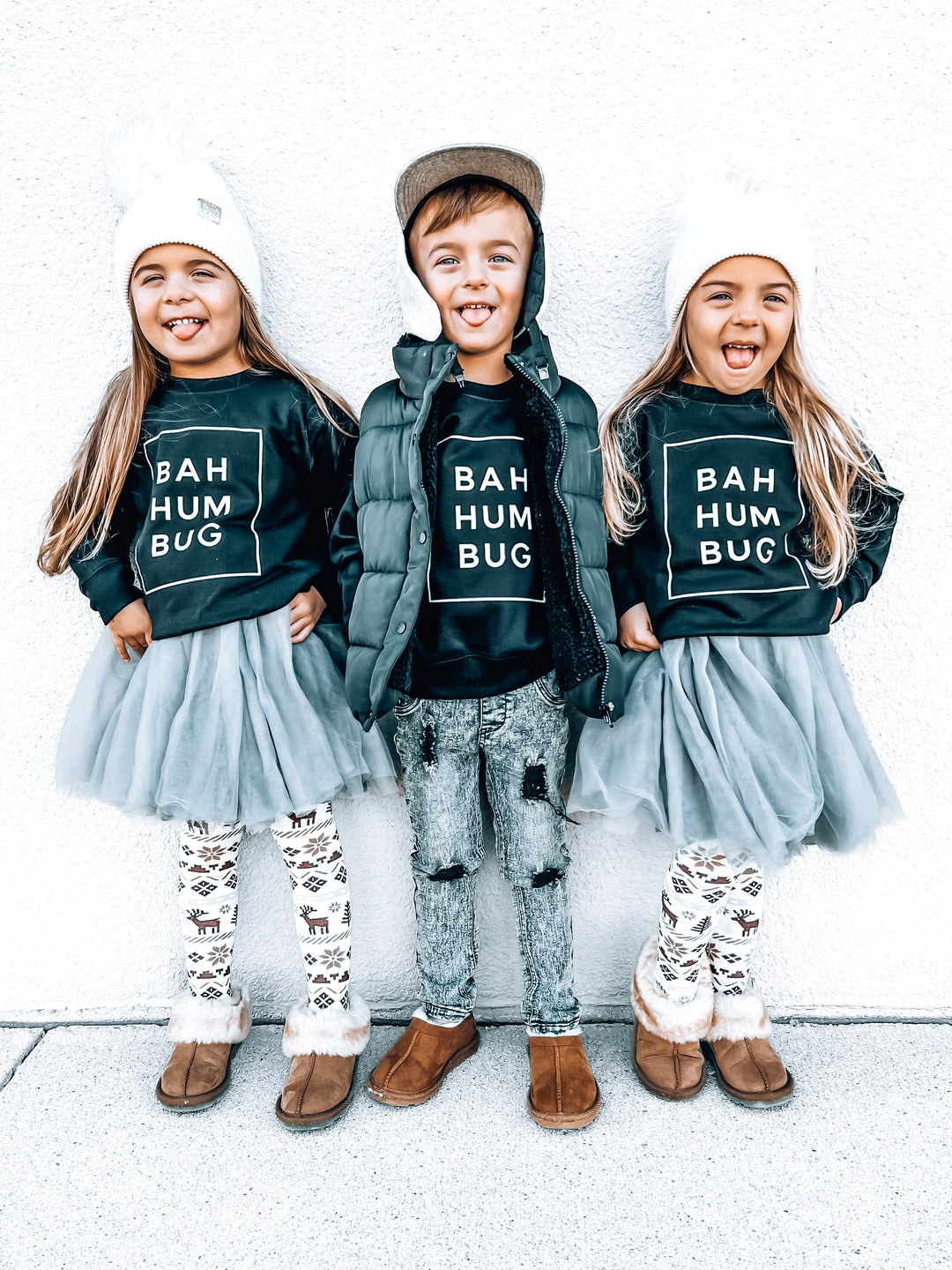 Three kids wearing black sweatshirts with the text "BAH HUM BUG" on the front.