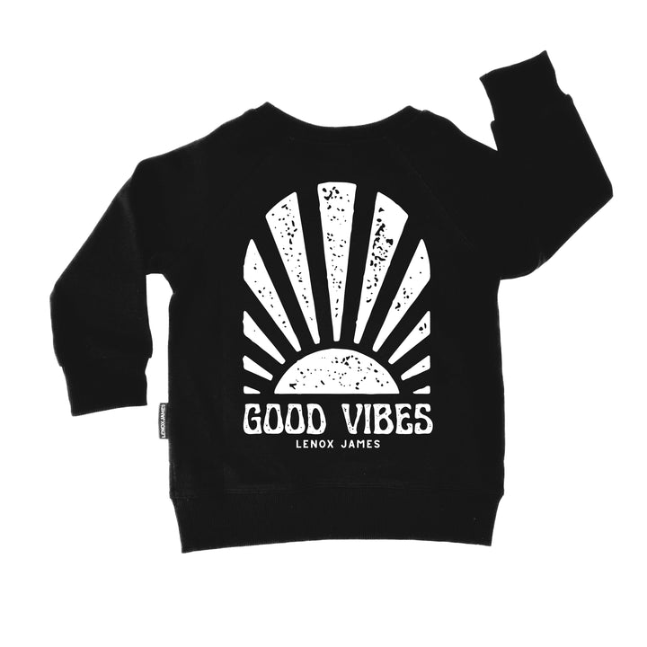Black sweatshirt with 'Good Vibes' design and brand name on a white background