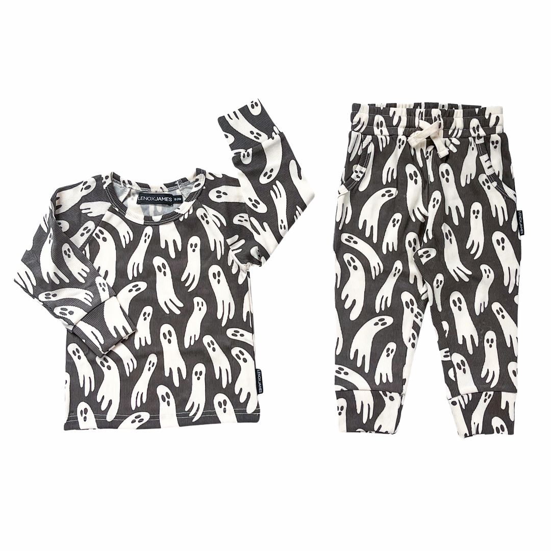 A two-piece baby clothing set featuring a long-sleeve top and matching pants, both printed with a playful pattern of white cartoon ghosts on a dark charcoal gray background.