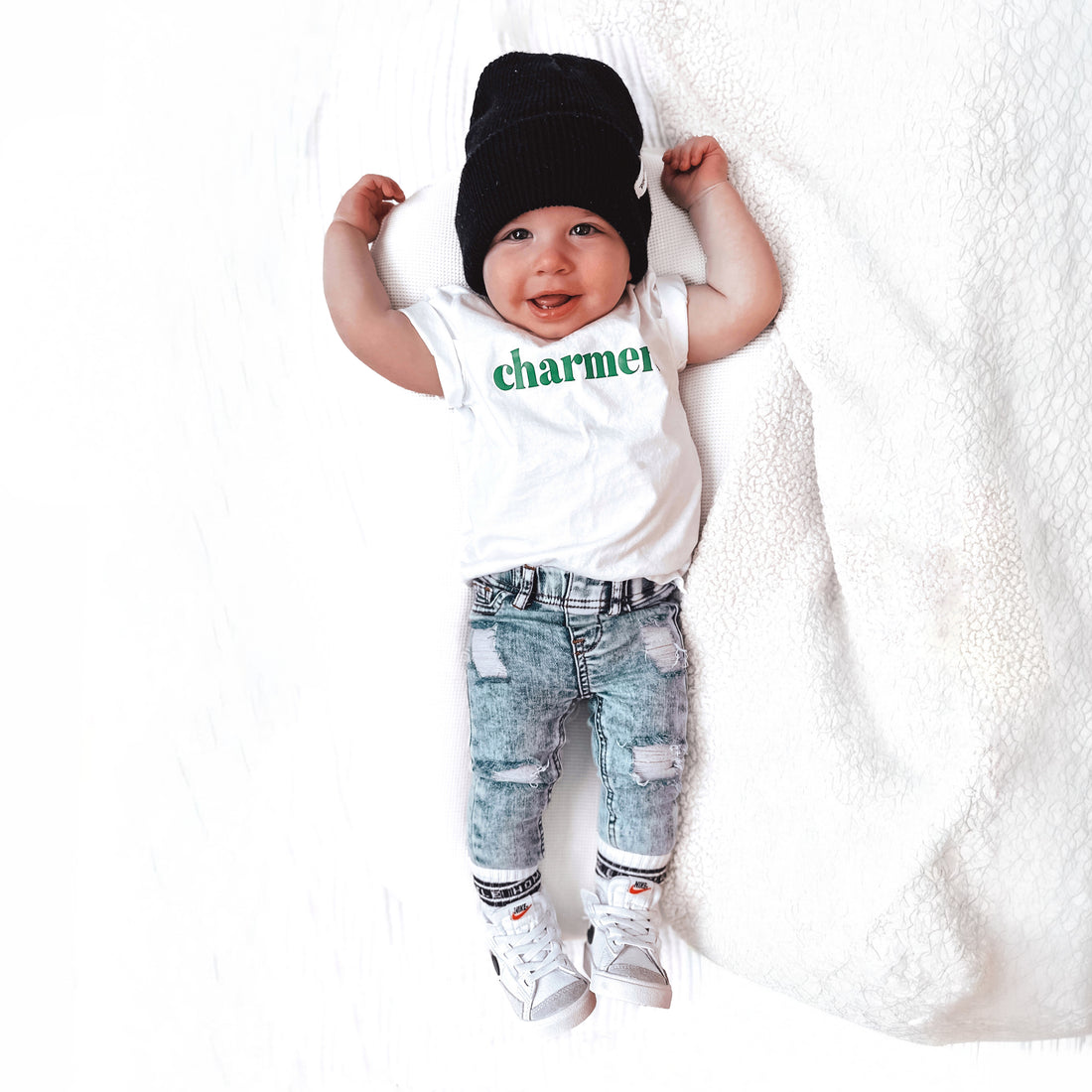 Baby wearing LENOX JAMES light wash distressed stretch jeans with a graphic tee and black beanie