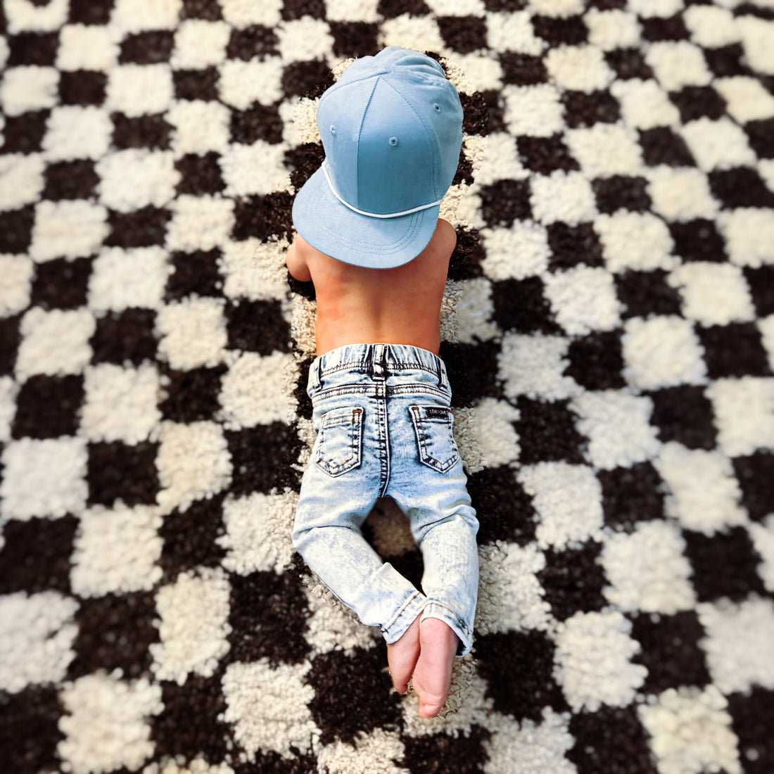 Baby wearing LENOX JAMES light wash stretch jeans and blue cap
