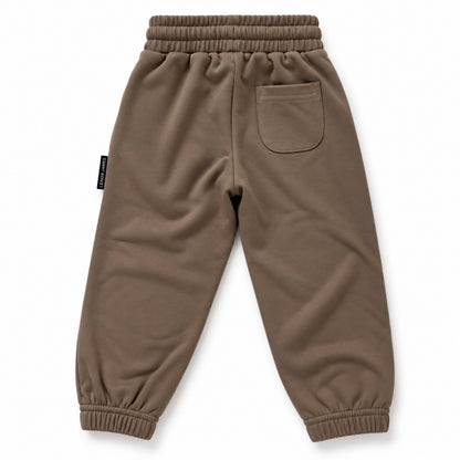 Back view of LENOX JAMES kids joggers in earthy brown with olive undertones, showing the rear patch pocket, elastic waistband and gathered cuffs.