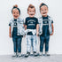 Three children wearing matching outfits with text on a white background