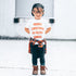 Child wearing LENOX JAMES Filthy Animal white Christmas graphic tee with red holiday lettering, black pants and plaid shirt tied at waist